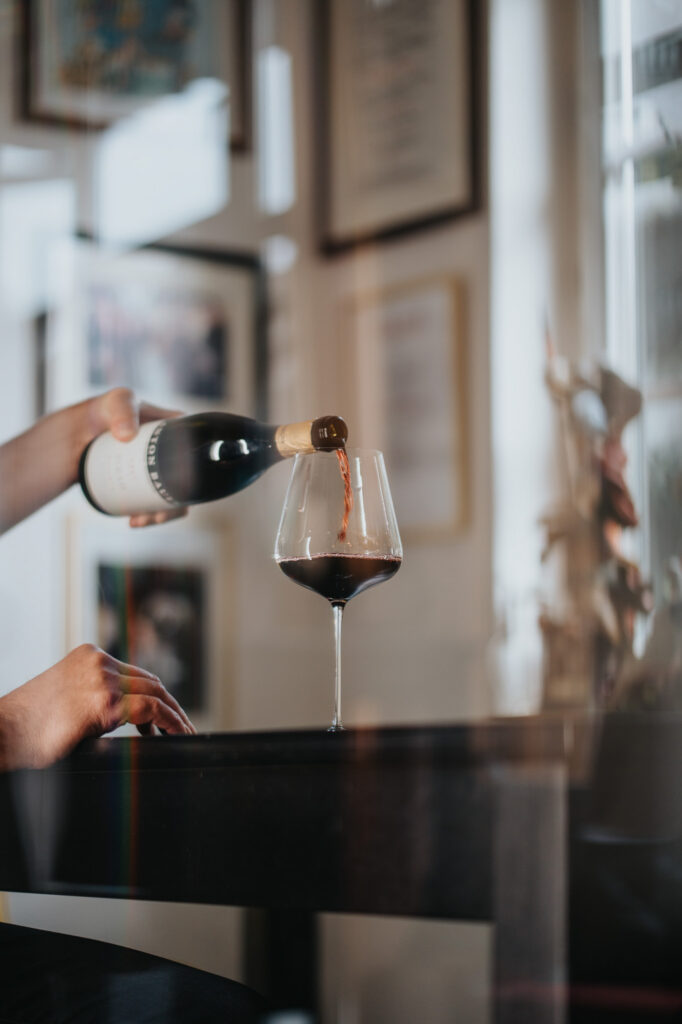 Rotwein wird im Verkostungsraum in ein Glas gegossen